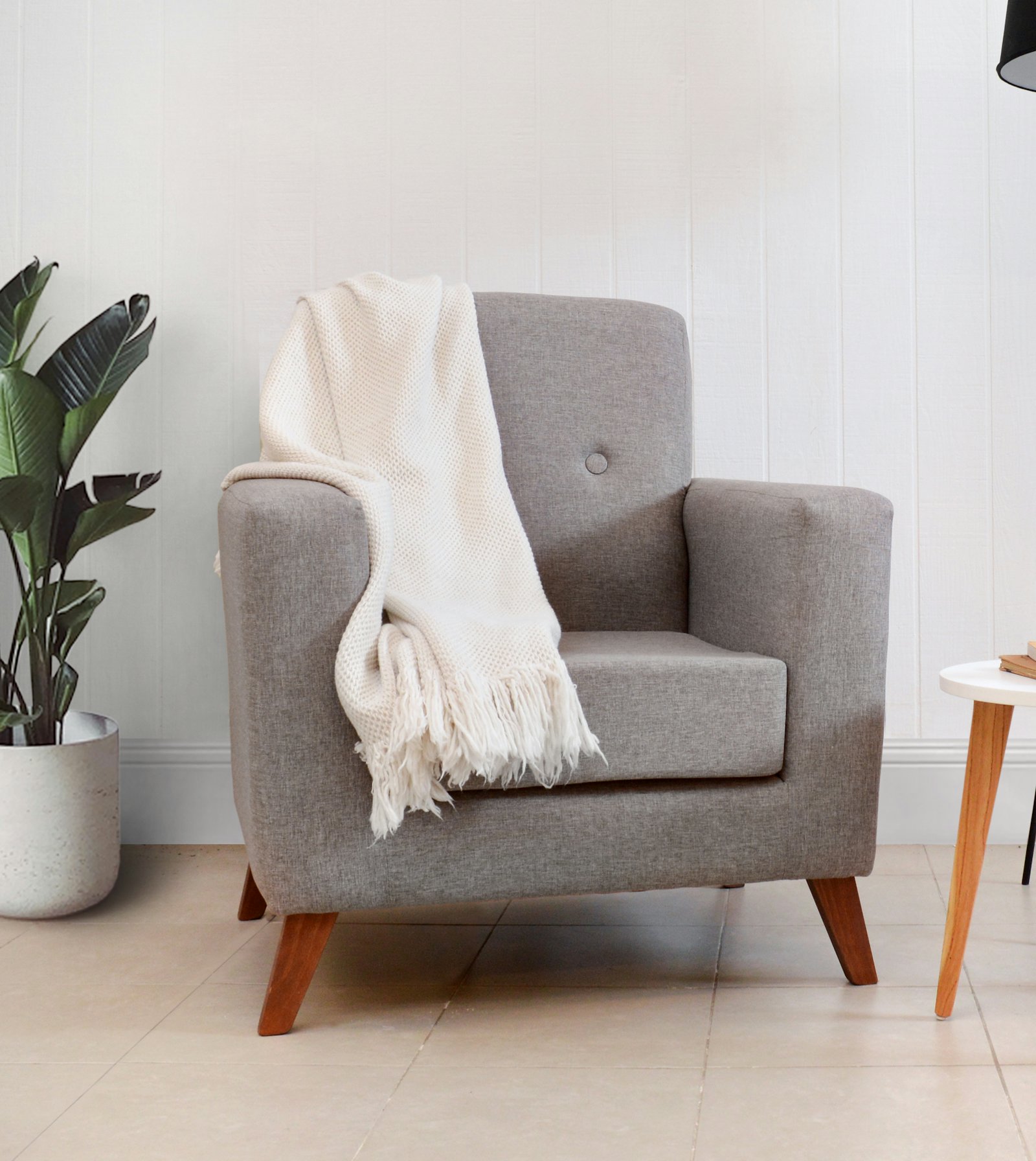 An armchair with a blanket and a touchscreen showing one large button